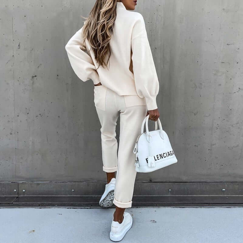 Casual high neck long sleeve pocket trousers two-piece suit in beige, paired with a white handbag and sneakers.