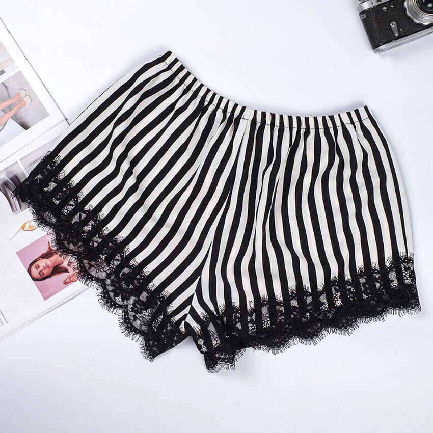 Pink and black and white striped satin pajama shorts with lace trim, perfect for summer home wear.