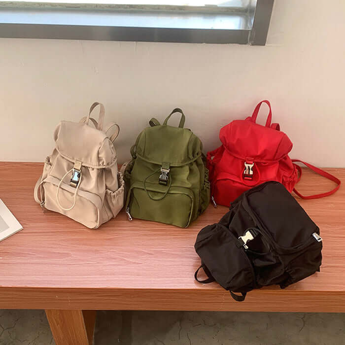Stylish small backpacks in red, green, apricot, and black on display, perfect for school and casual outings.