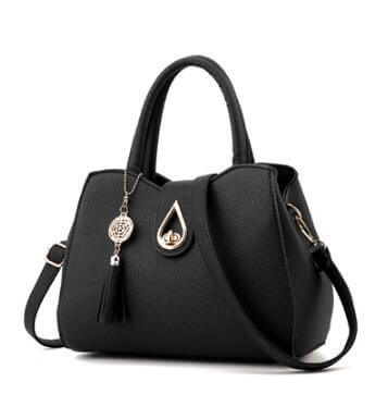 Stylish women's handbag in black PU leather with tassel and decorative charm, featuring a shell shape and zipper closure.