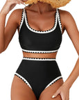 Women's black bikini swimsuit with contrasting white trim, perfect for swimming and beach activities.