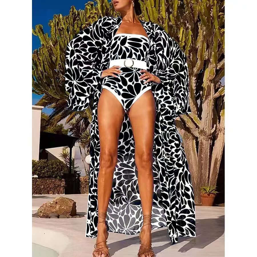 Women's long-sleeved floral one-piece swimsuit with matching cover-up in black and white, perfect for summer swims.