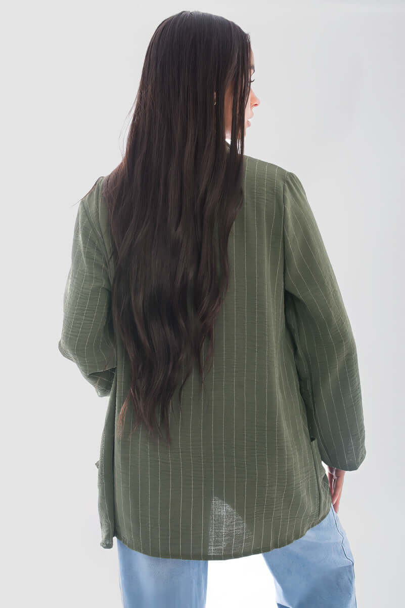 Back view of a woman wearing an oversized olive green striped cardigan with long sleeves.