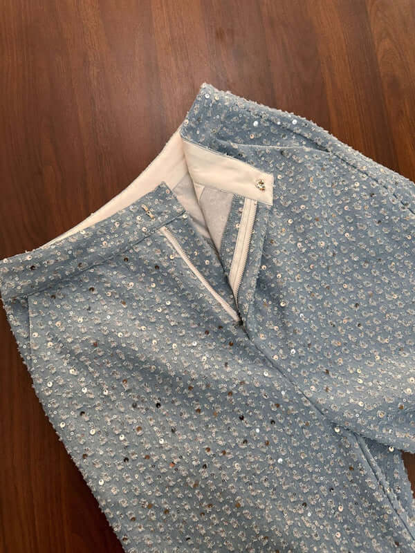 Close-up of women's casual sequined denim straight pants, featuring a blue fabric and hidden zipper detail.