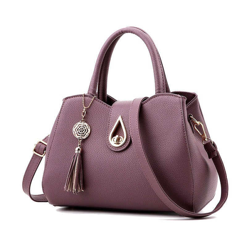 Fashion women's handbag in purple PU leather with tassel and zipper closure, perfect for stylish outings.