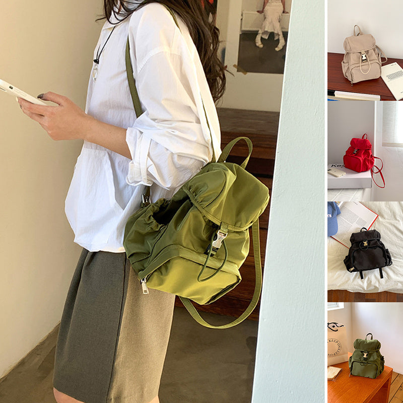 Fashionable green nylon small backpack, perfect for casual outings and school, modeled by a woman in a stylish setting.