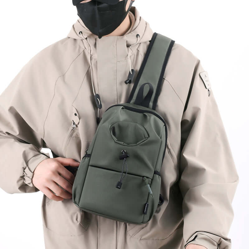 Men's Oxford cloth splash-proof shoulder crossbody bag in dark green, worn by a male model in a stylish outdoor outfit.