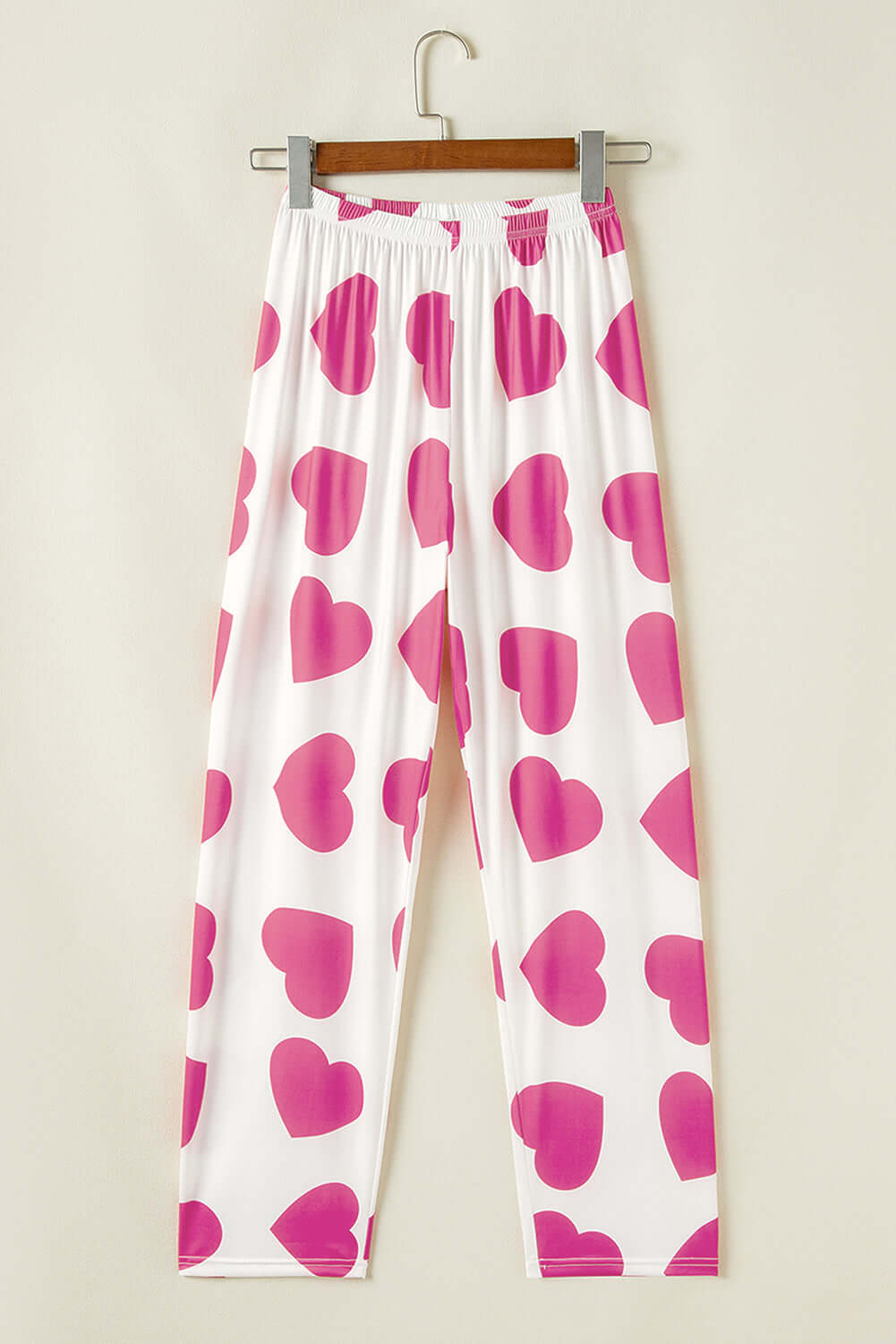 White lounge pants with large pink heart prints, stylish women&#39;s pjs, perfect for relaxing at home.