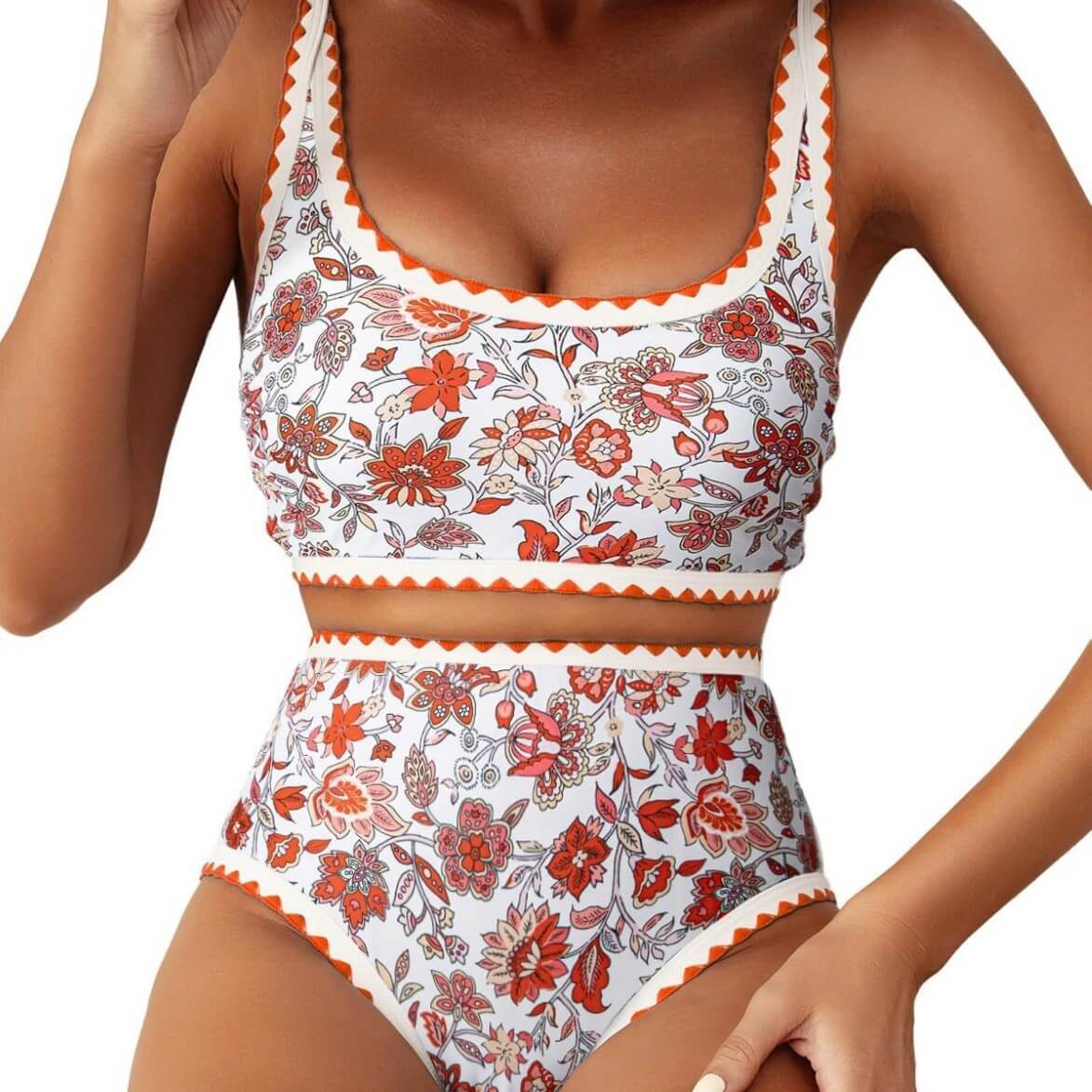 Women's swimwear featuring a floral paisley pattern bikini top and high-waisted bottom in vibrant orange and white.