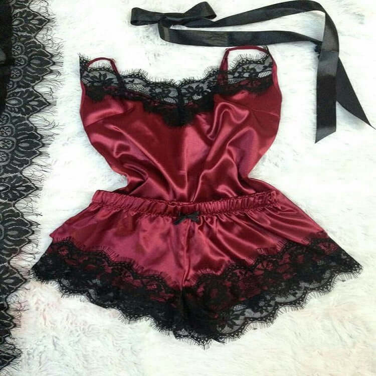 Burgundy satin women's pajama set with lace trim featuring a tank top and shorts.