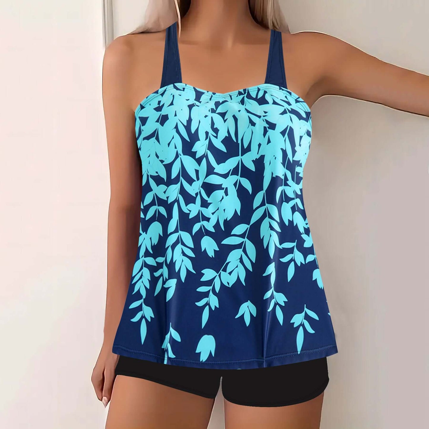Plus size women's swimwear featuring a navy blue tankini with a split leaf print in aqua shades.
