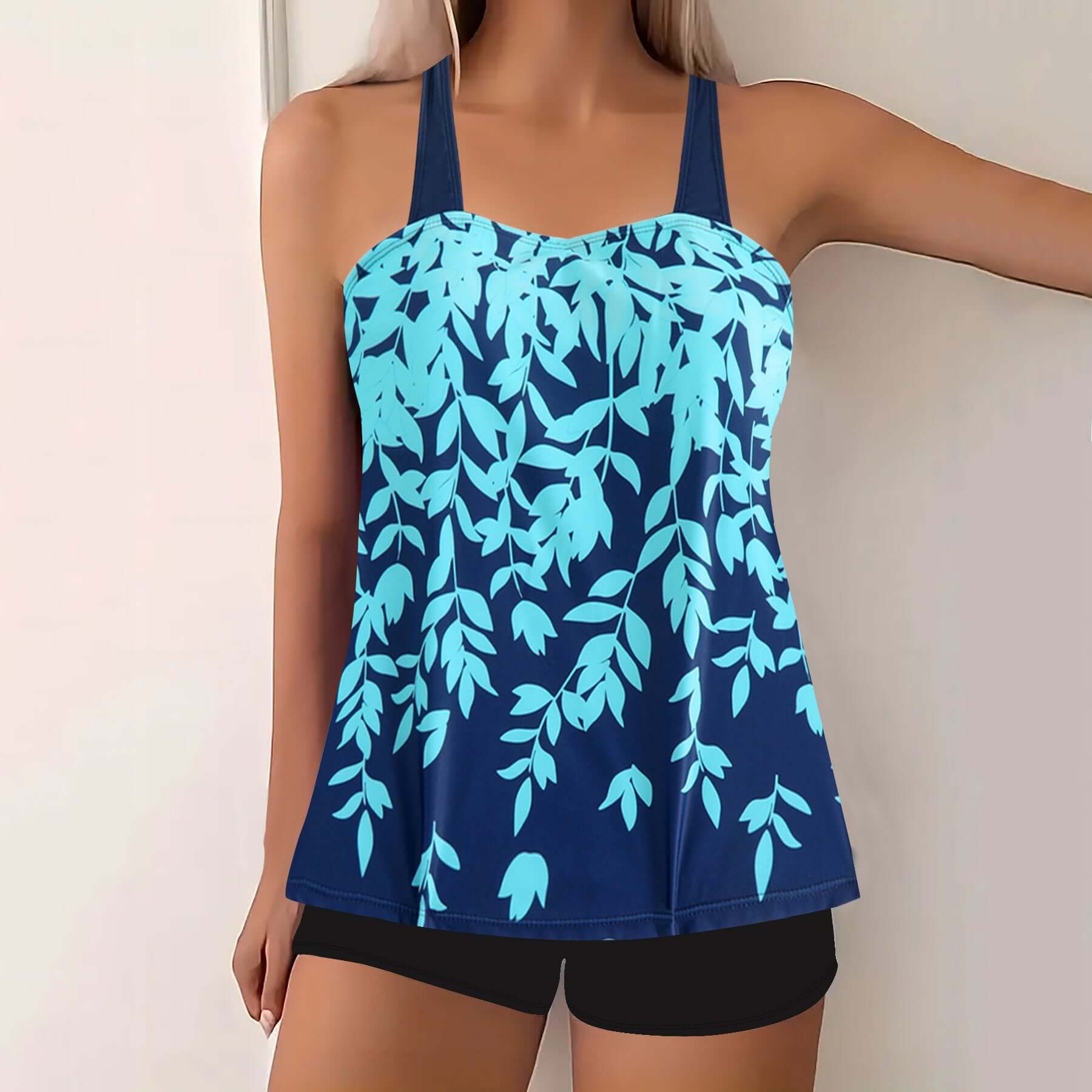 Plus size women's swimwear featuring a navy blue tankini with a split leaf print in aqua shades.