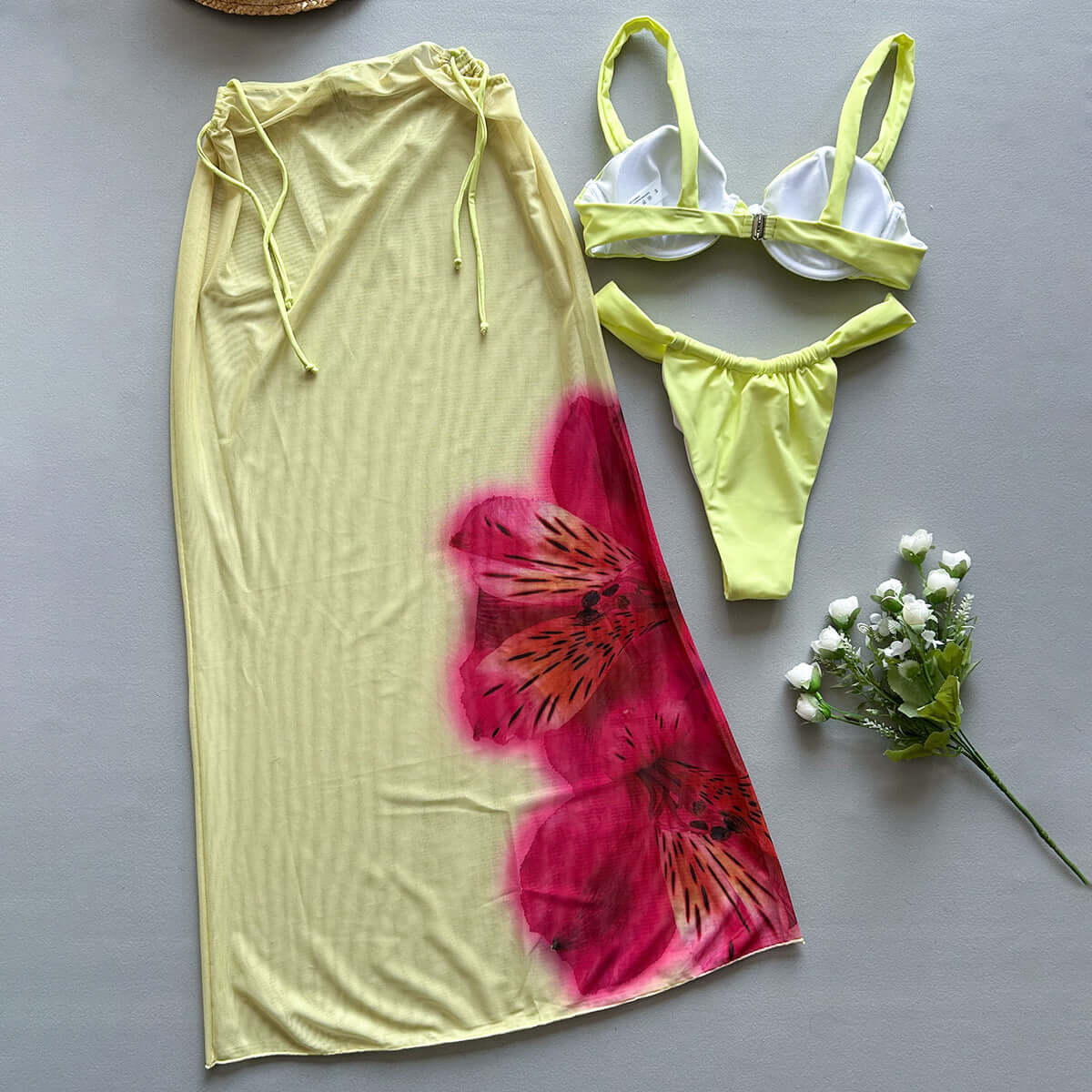 Three-piece yellow printed women's bikini swimsuit with floral design and matching cover-up, perfect for beachwear.