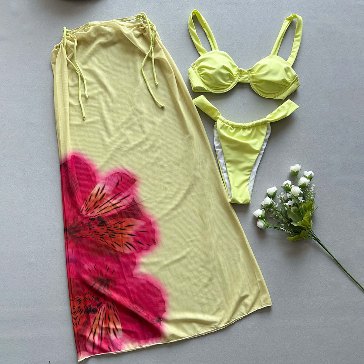 Three-piece women's swimwear featuring a yellow printed bikini and matching cover-up with floral design.