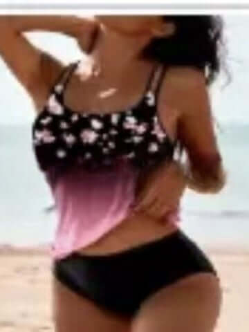 Woman in floral bikini top and black bottom at the beach, showcasing stylish women's swimwear for summer.