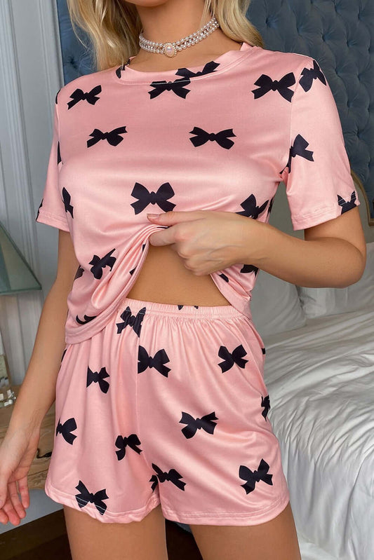Model wearing a pink bow printed short two-piece lounge set, perfect for women's PJs from Little Miss Vanilla Clothing UK.