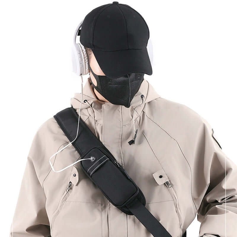 Stylish male model wearing a black cap and headphones with a men's Oxford cloth crossbody chest bag.