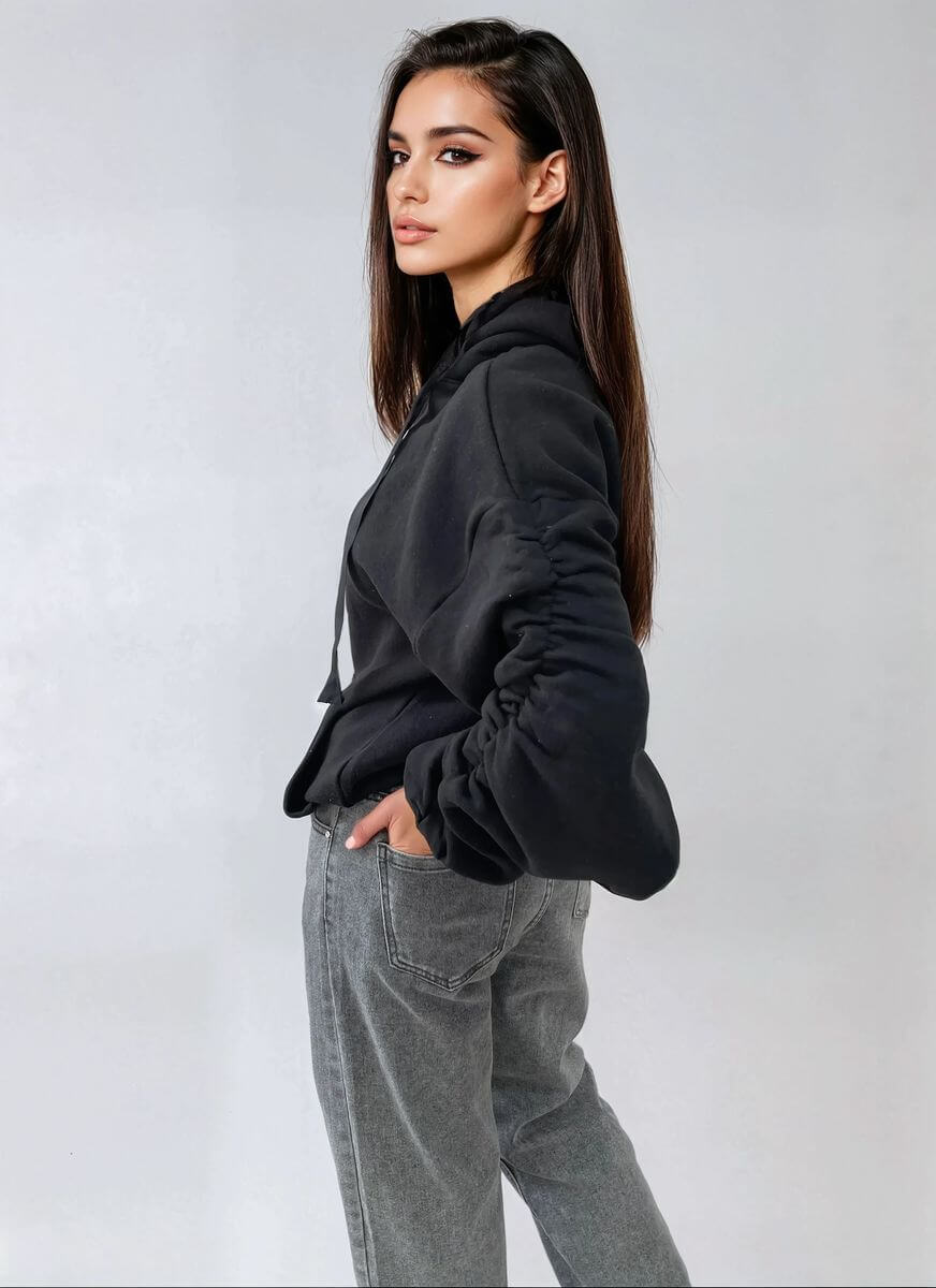 Model wearing a cozy ruched sleeve oversized hoodie with front pouch pocket, styled with casual gray jeans.