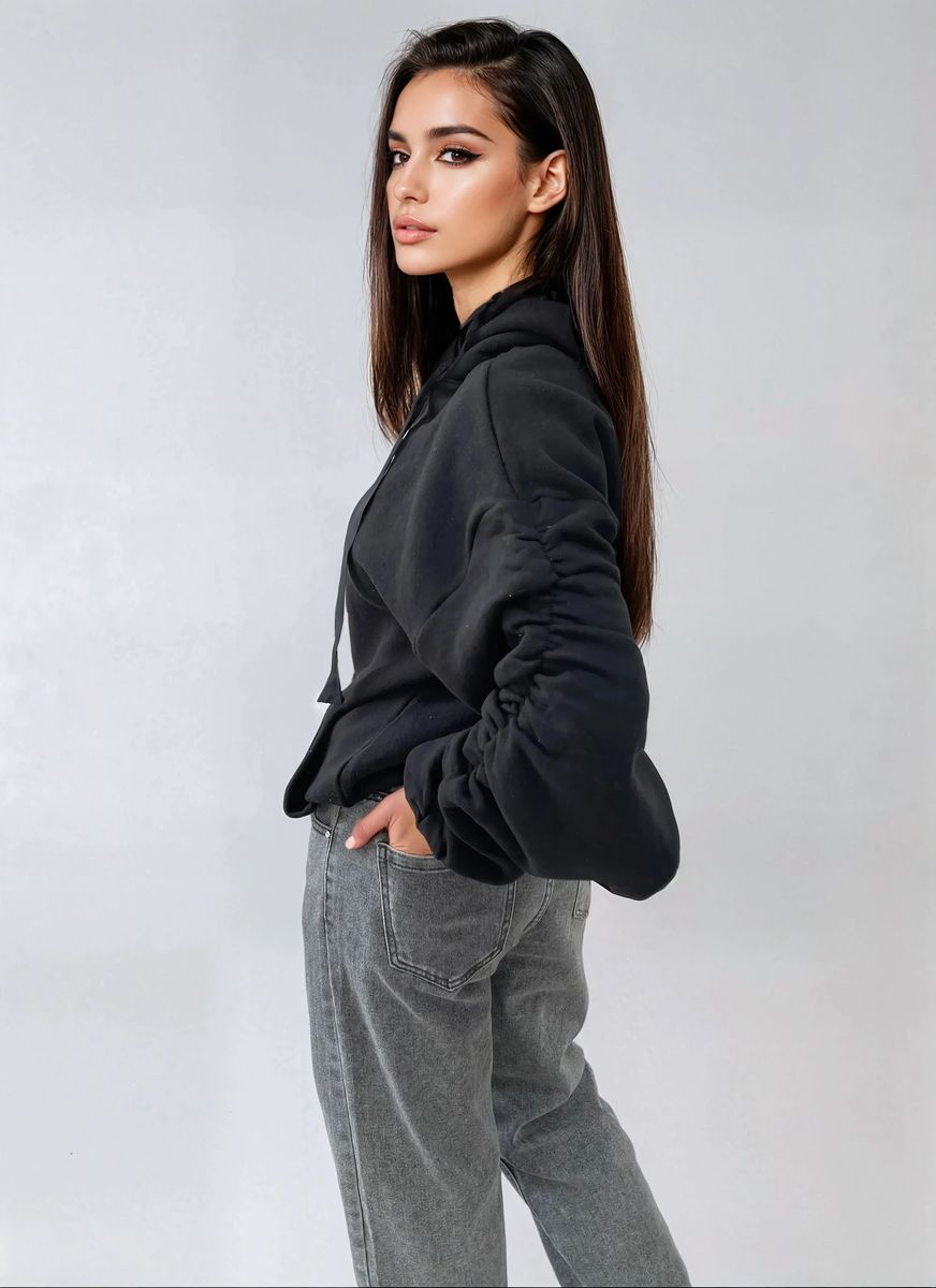Model wearing a cozy ruched sleeve oversized hoodie with front pouch pocket, styled with casual gray jeans.
