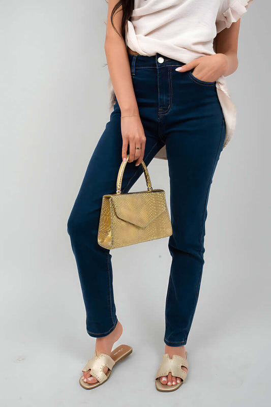 Woman wearing Clara Straight Leg High Waist Jeans with gold handbag and sandals, styled for casual elegance.