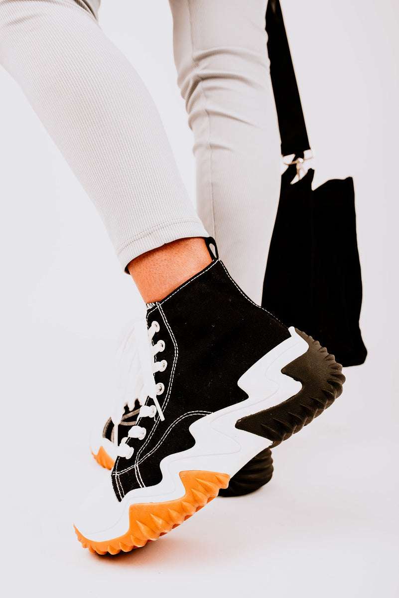 Stylish black and white chunky platform lace-up trainers with unique zigzag sole, perfect for casual outfits.