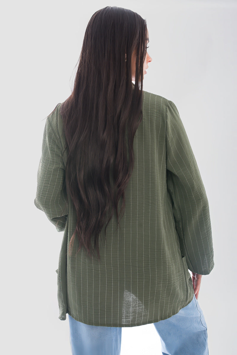 Back view of a woman wearing an oversized olive green striped cardigan with long sleeves.