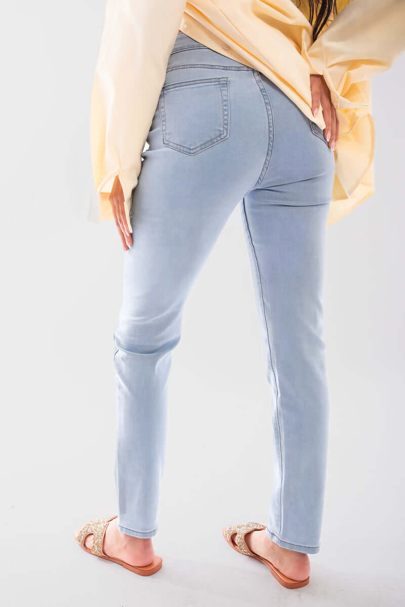 Back view of high waisted skinny fit jeans paired with a light yellow top and sandals, showcasing a stylish and comfortable fit.
