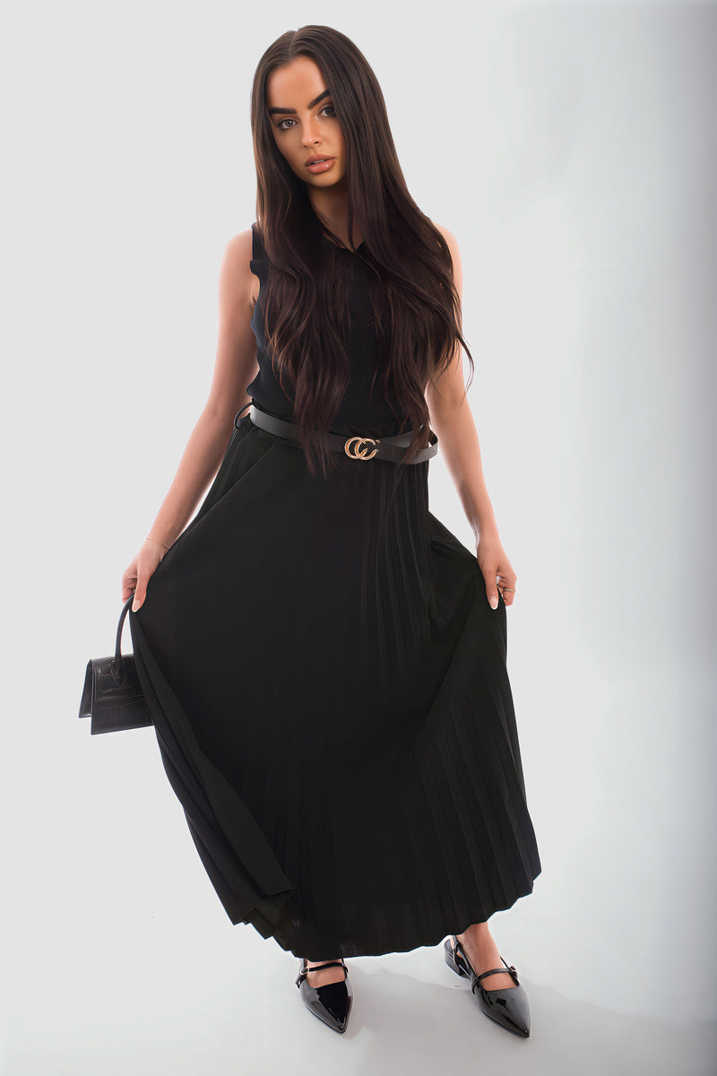 Woman wearing a belted black pleated maxi skirt made of organic cotton, showcasing a relaxed fit and stylish look.